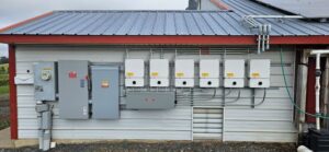 SolarEdge inverters and electrical panels on a poultry farm building wall