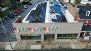 Aerial view of the Festiva Laundry storefront with solar panels across the flat roof